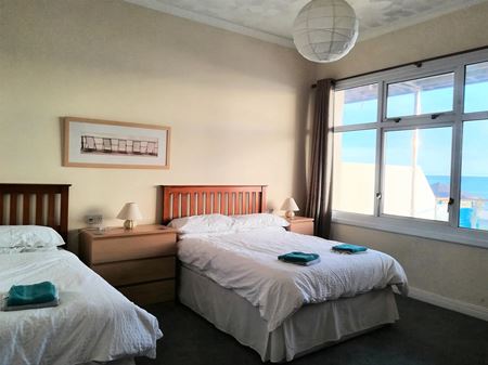 Main bedroom showing double and single bed and large window